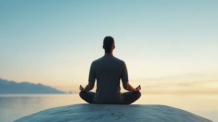 Poster - A man is sitting on a rock by the water, meditating