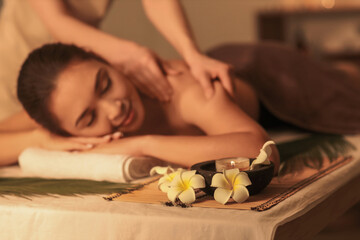 Wall Mural - Young Asian woman getting massage in dark spa salon, closeup