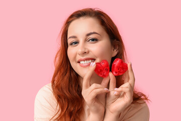 Sticker - Beautiful young woman holding heart-shaped soap bars on pink background