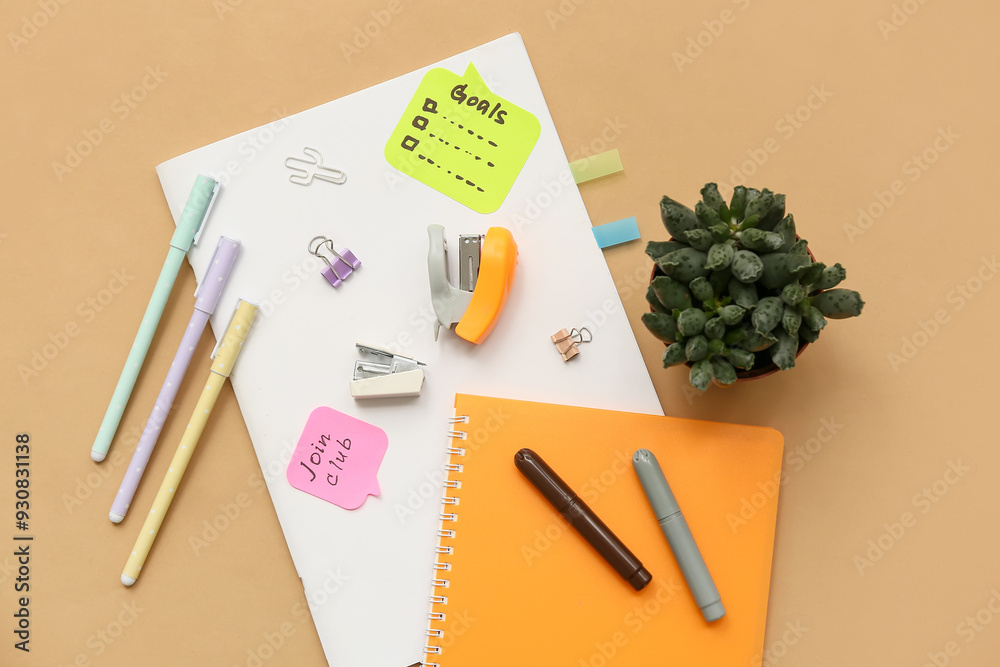 Sticky notes with to do plans, notebooks and stationery on beige background. New year goals concept
