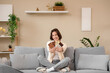 © Pixel-Shot - Beautiful young happy woman with different tasty chocolate bars sitting on sofa at home