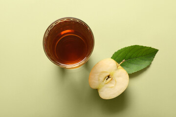 Wall Mural - Glass of fresh apple juice on green background