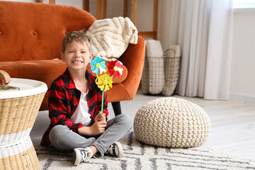 Canvas Print - Cute little boy with toy windmill sitting on floor at home