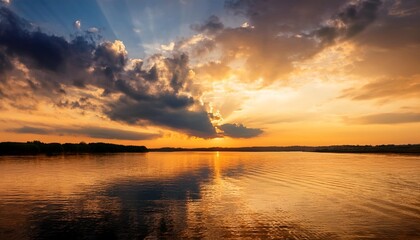 Wall Mural - ripples on surface of wide river with dramatic sunset sky