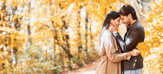 Wall Mural - Romantic couple hugging and talking about love, dating in autumn park, copy space