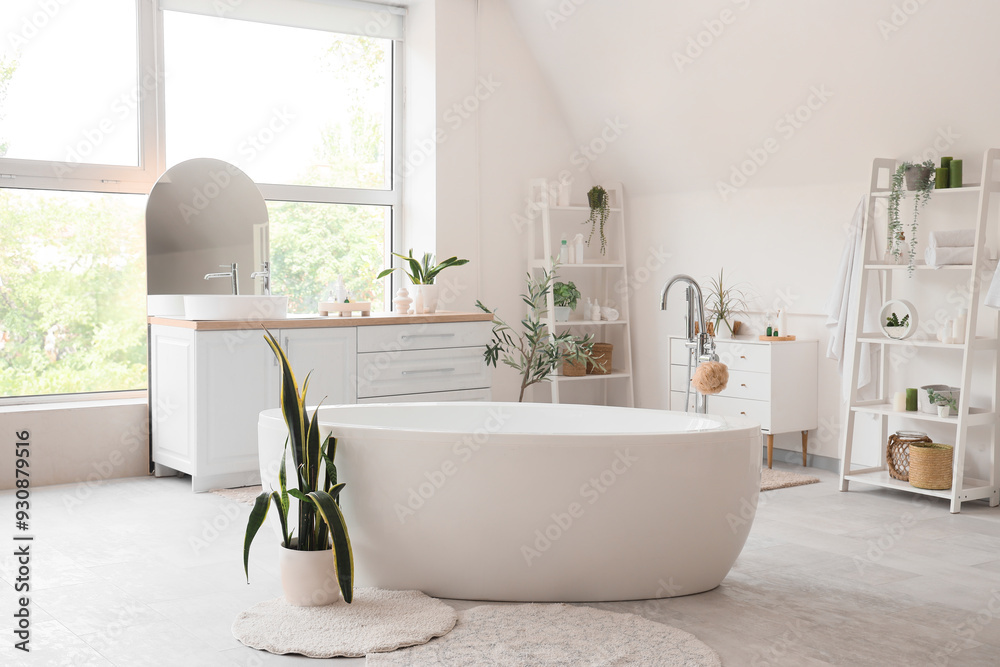 Interior of light bathroom with counters, shelf units and bathtub