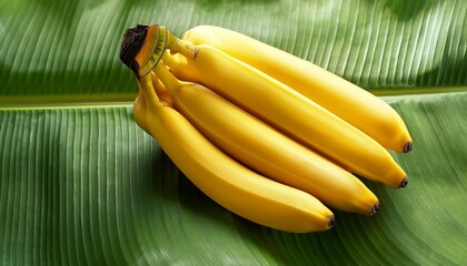 Wall Mural - perfect ripe yellow bananas on green banana leaf close up