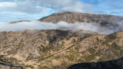 Wall Mural - Aerial view of the mountains shrouded in cloud in Torlesse Tussocklands Park