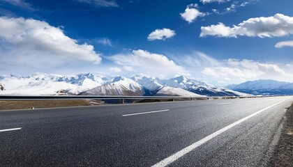 empty asphalt road with snow mountains in blue cloud sky