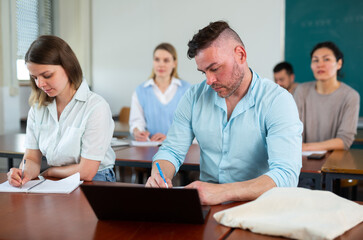 Sticker - Handsome adult male student typing on laptop during lecture at university