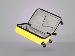 Poster - Open empty suitcase in air on light grey background