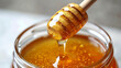 © LOPH Studio - Macro shot of honey drizzling from honey dipper into jar with natural golden shine.