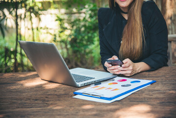 Sticker - Asian Female freelance using laptop at home office desk. Woman reading financial graph chart Planning analyzing marketing data. Asian female people working office firm with business stuff, coffee cup