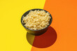 © kvladimirv - Bowl of Plain Instant Noodles on Bright Orange and Yellow Background