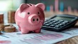 © keks20034 - A pink piggy bank on the background of financial charts and a calculator symbolizes financial management