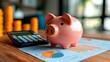 © keks20034 - A pink piggy bank on the background of financial charts and a calculator symbolizes financial management