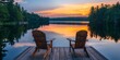 © Thanthara - Two wooden chairs on a wood pier overlooking a lake at sunset