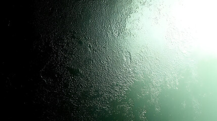 A textured gradient surface with a greenish hue and light reflection.