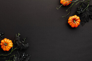 Wall Mural - Spooky Halloween flat lay composition with pumpkins, maple leaves, branches on dark background. Top view with copy space.