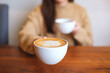 © Farknot Architect - Closeup image of a woman holding and serving two cups of hot coffee