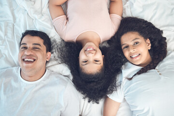 Poster - Mom, dad and kid in portrait on bed with smile, love and relax in morning together from above. Mother, father and girl child bonding in bedroom with happy family, fun and care on weekend in home