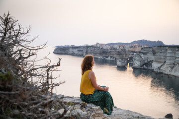 woman watching the sunset over the town of bonifacio corsica island france