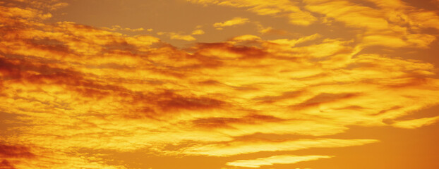 Wall Mural - Golden cloudy sky at sunset. Sky texture. Abstract nature background