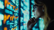 © Piyatad - Female analyst viewing financial market data on a screen.