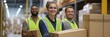 © Iryna - A woman wearing a yellow vest is smiling as she carries a box. She is surrounded by two men in yellow vests