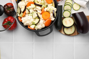 Canvas Print - Cooking stew. Cut raw vegetables in pot on white tiled table, flat lay