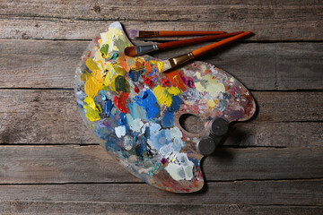 Poster - Artist's palette, brushes and paints on wooden table, flat lay