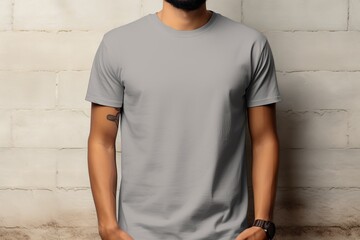 Poster - Front view mockup of a man wearing a grey simple t-shirt against a concrete wall background, ideal for fashion and branding presentations