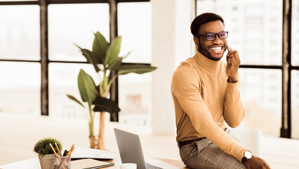 Poster - Communication Concept. Black businessman talking on mobile phone in modern office. Panorama with copy space