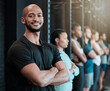 © Haas/peopleimages.com - Fitness, gym and man in row for portrait, confidence and ready for workout in class. Arms crossed, personal trainer and smile in training center for exercise, wellness and determination for growth