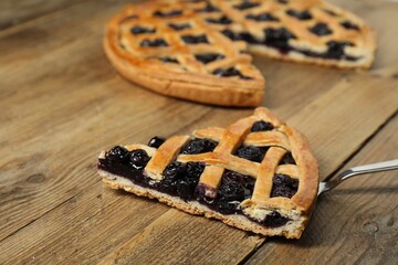 Wall Mural - Piece of tasty homemade blueberry pie and server on wooden table, closeup