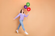 © deagreez - Full body portrait of nice young woman balloons jump empty space wear cardigan isolated on beige color background