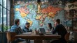 © Yamato - Group of People Sitting at a Table in a Cafe with a World Map on the Wall
