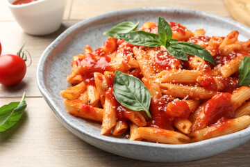 Wall Mural - Delicious pasta with tomato sauce, basil and cheese on wooden table, closeup