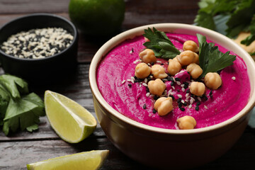 Wall Mural - Tasty beetroot hummus in bowl and products on wooden table, closeup