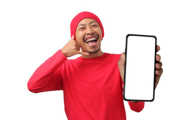 Young Indonesian man in a red long sleeve shirt shows a phone with an empty white screen while making a 