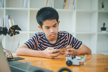 Asian boy learning and studying the work of technology robots.homeschool and science for tech project. playing childhood kids hobby leisure lifestyle people toys robotics technology.