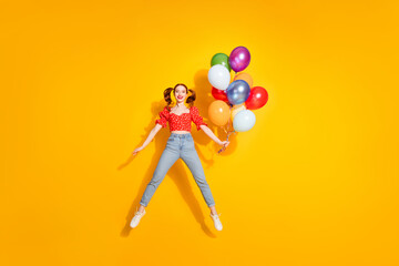 Canvas Print - Photo of young red hair funky positive girl wearing blouse and jeans flying helium air balloons entertainment isolated on yellow color background