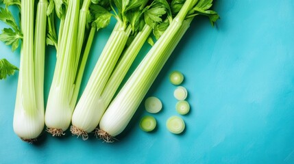 Wall Mural - Fresh Green Celery Stalks on a Blue Background