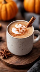 Wall Mural - Pumpkin spice latte topped with a cinnamon stick nestles on an aged wooden table encapsulating the snug autumnal spirit of October 