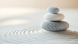 © mimi - A balanced stack of smooth stones rests on sand with gentle ripples, symbolizing serenity, balance, and tranquility in a minimalist zen setting.