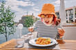 © EdNurg - Hungry seafood lover eagerly digging into a fresh and flavorful pasta dish outdoors.