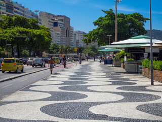 Wall Mural - Copacabana beach with palms and mosaic of sidewalk in Rio de Janeiro, Brazil. Copacabana beach is the most famous beach in Rio de Janeiro. Sunny cityscape of Rio de Janeiro