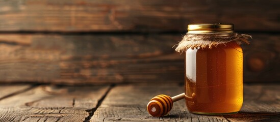 jar of honey and stick on a wooden surface. with copy space image. Place for adding text or design