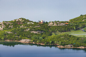 Wall Mural - Aerial view of the island monastery on Lake Skadar, Montenegro, surrounded by pristine blue waters.