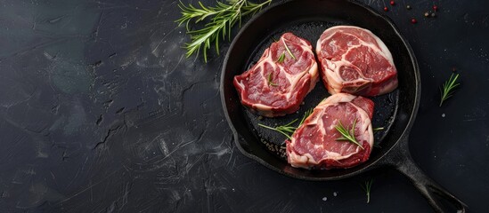 Poster - Pork ribeye roast in a skillet grill with herbs and spices viewed from above on a black stone background with space for text. with copy space image. Place for adding text or design